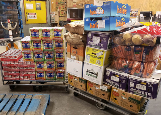 Stacks of groceries in a grocery store back room sitting on pallets.