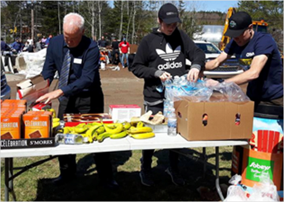 Store employees stacking food and water in boxes.