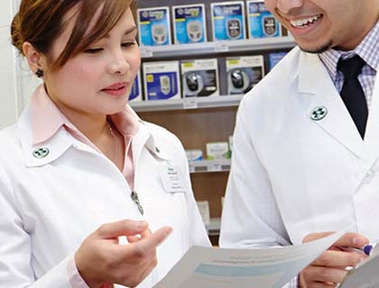 Pharmacists talking together while looking at a paper