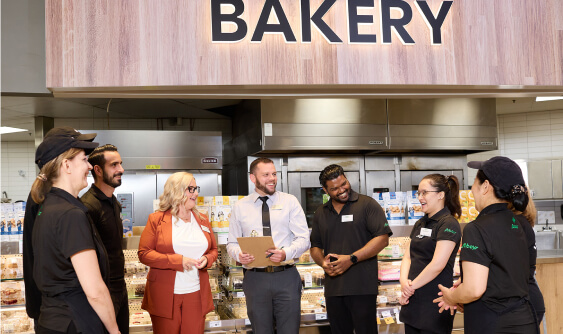 In this image, a group of Sobeys employees is discussing something together and laughing.